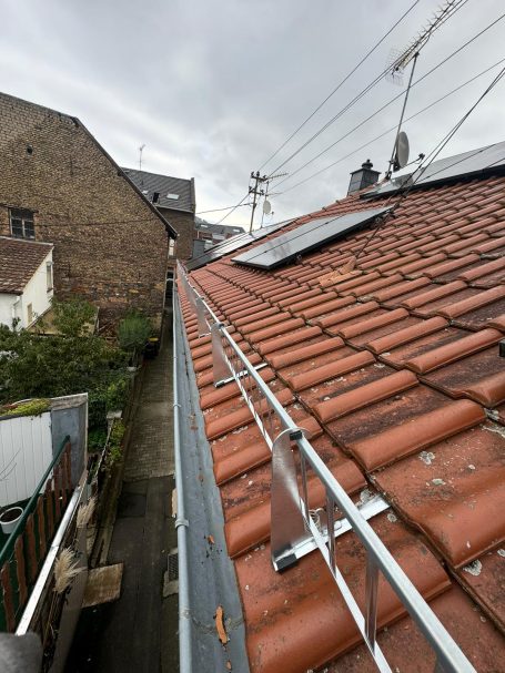 Dach mit roten Ziegeln, Regenrinne, Fallrohr, Schnee Gitter